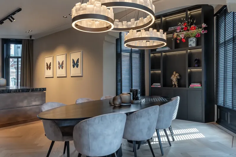 Eetkamer met ovale tafel en maatwerkkast in zwart eiken, na een totaalrenovatie door Nivara
